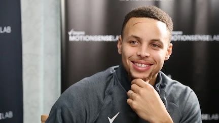 Stephen Curry smiling during a seated interview